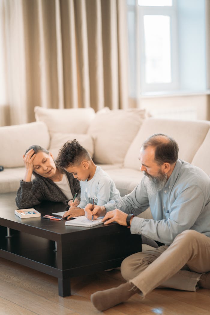 A cheerful family scene with grandparents and a child drawing together in a cozy living room.